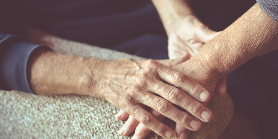 Personas mayores tomándose las manos. © Shutterstock / Predrag Popovski.