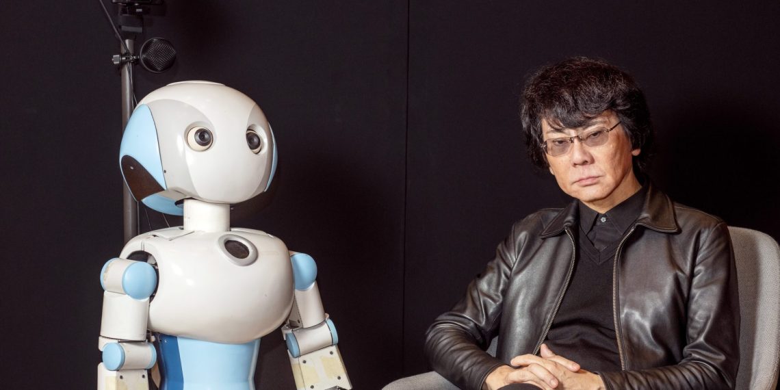 El roboticista e ingeniero Hiroshi Ishiguro junto a Robovie, una de sus creaciones. © Adrián Quiroga. Fundación "la Caixa"