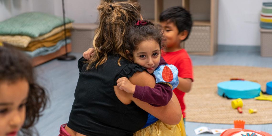 Una niña abrazando a una de las educadoras de CaixaProInfancia en la entidad Gazteleku de Bilbao. Foto: Fundación La Caixa